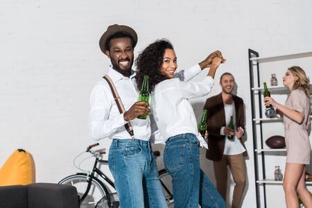 Selective focus of African American man and woman dancing near friendsの写真素材