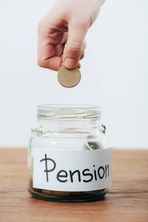 Partial view of man putting dollar banknote in piggy bank isolated on white backgroundの写真素材