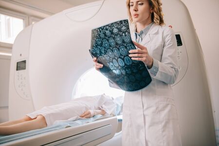 Attentive radiologist examining tomography diagnosis during patients diagnosticsの写真素材