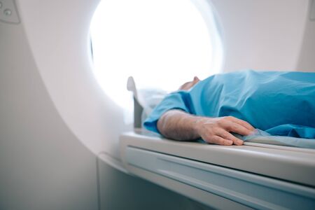 Selective focus of patient lying on ct scanner bed during tomography testの写真素材