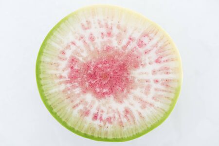 top view of cut raw purple fresh watermelon radish slice on white background
