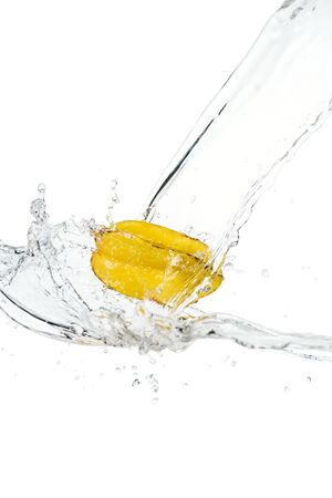 whole ripe star fruit and water splash with drops isolated on whiteの写真素材