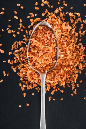 top view of orange candied fruit in silver spoon on black backgroundの写真素材