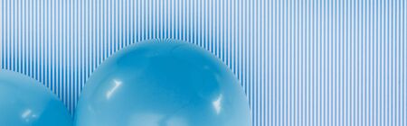 Panoramic shot of blue balloons on blue and white striped backgroundの写真素材