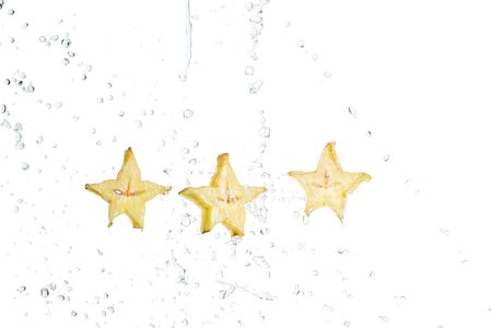 fresh exotic star fruit slices and water drops isolated on white