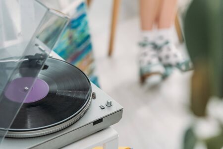 partial view of girl in dotted socks and record player with vinyl discの写真素材