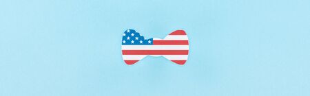 top view of paper cut decorative bow tie made of american flag on blue background, panoramic shot