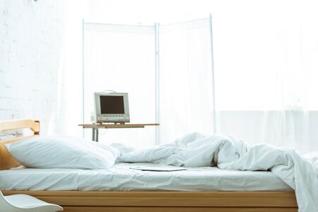 empty bed and medical equipment in hospital ward