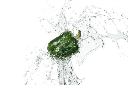 green fresh bell pepper with clear water splash isolated on whiteの写真素材