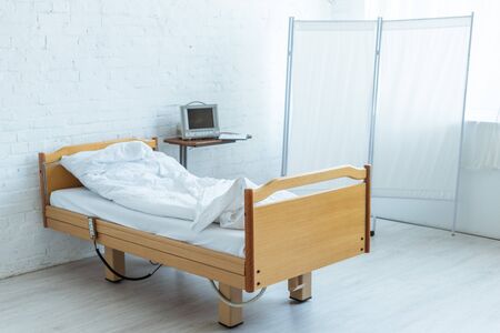 empty bed and medical equipment in ward in clinic
