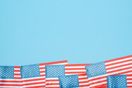 top view of american flags on blue background with copy space