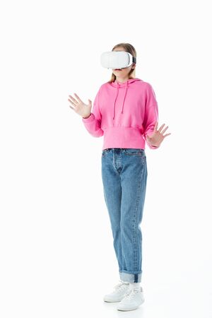 teenage girl in pink hoodie and jeans wearing vr headset and gesturing isolated on whiteの写真素材