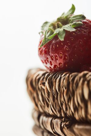 Fresh red strawberries in wicker basket isolated on white backgroundの写真素材