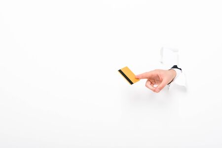 Partial view of man holding Credit card from hole in wall on white background with copy spaceの写真素材