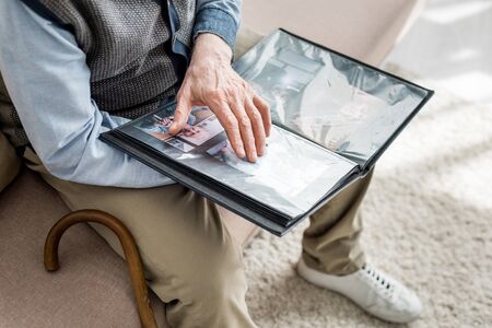 Cropped view of senior man holding photo album in handsの写真素材