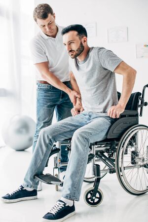 Physiotherapist helping handicapped man in Wheelchair during recoveryの写真素材