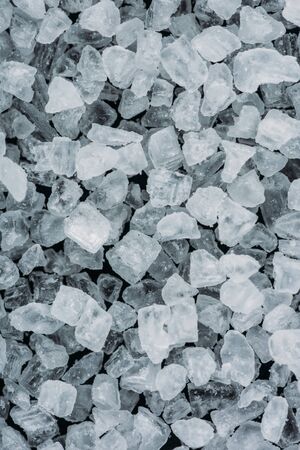 Top view of white salt crystals on black surface