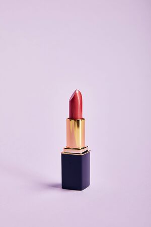 Single opened tube of red lipstick on purple backgroundの写真素材