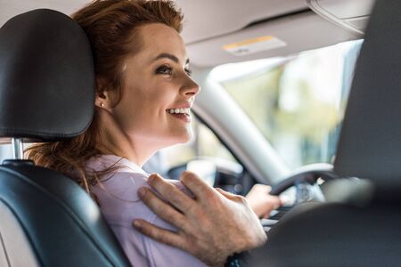 Cropped view of man touching shoulder of woman in car