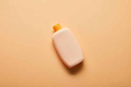 Top view of sunscreen lotion in bottle on beige backgroundの写真素材