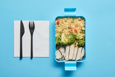 Top view of lunch box with risotto, broccoli and chicken on blue backgroundの写真素材