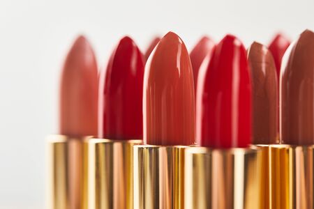 Selective focus of various red shades of lipstick in tubes isolated on grey backgroundの写真素材