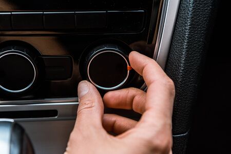 Cropped view of man touching volume button in car