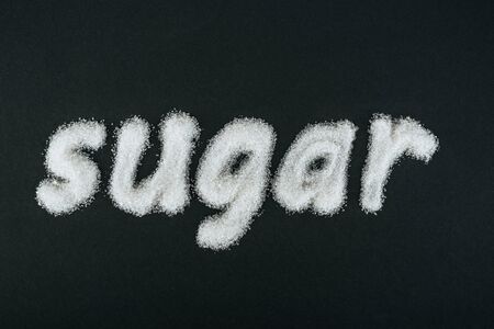 Top view of word sugar made of white sugar crystals on black backgroundの写真素材