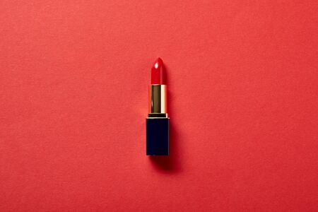 Top view of single tube of red lipstick on red backgroundの写真素材