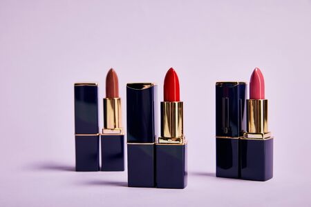 Various red shades of lipsticks in tubes on violet backgroundの写真素材