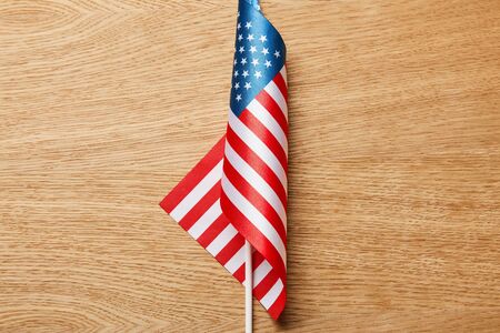 Top view of American flag on stick on wooden surface