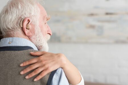 Cropped view of woman putting hand on grey haired manの写真素材