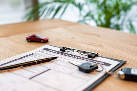 Selective focus of clipboard with document near pen, toy car and car keyの写真素材