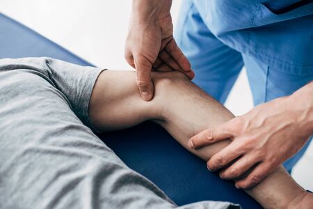 Partial view of chiropractor massaging arm of patient in hospitalの写真素材