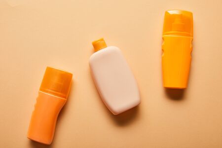 Top view of sunscreen products in bottles on beige backgroundの写真素材