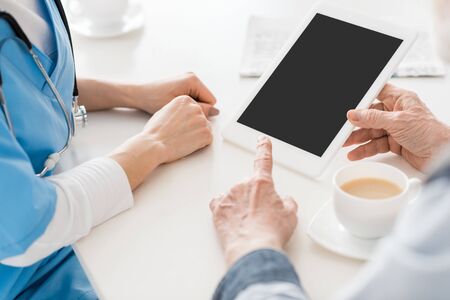 Cropped view of hands pointing at digital tablet with copy spaceの写真素材