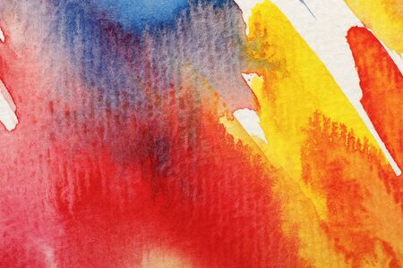 Close up view of wet yellow, blue and red watercolor paint brushstrokes on white backgroundの写真素材