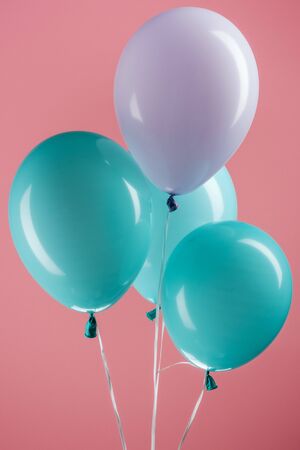 Blue and purple colorful decorative festive balloons on pink backgroundの写真素材