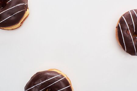 Top view of chocolate glazed doughnuts on white backgroundの写真素材