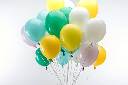 Bright green, yellow and blue decorative balloons on white backgroundの写真素材