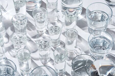 Close up view of transparent glasses with water on white background with shadowsの写真素材