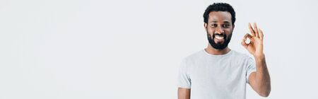 Cheerful African American man in grey t-shirt showing ok sign isolated on grey backgroundの写真素材