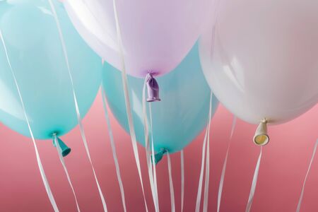 Close up view of blue, white and purple balloons on pink backgroundの写真素材