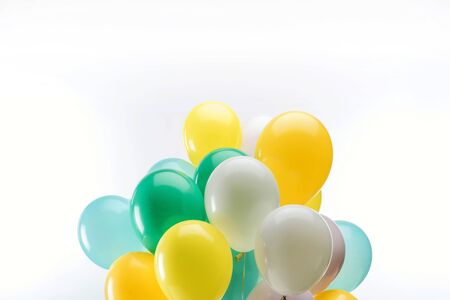Bright green, yellow and blue decorative balloons on white backgroundの写真素材