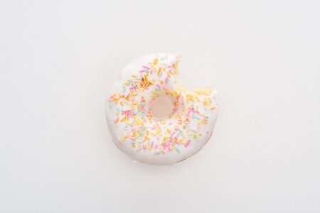 Top view of bitten white delicious doughnut with sprinkles on white backgroundの写真素材