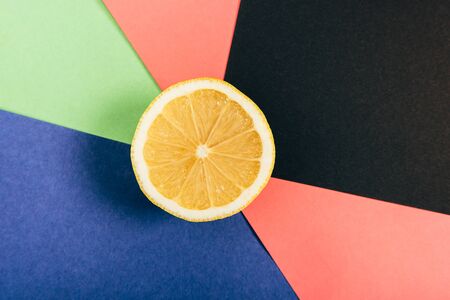 Top view of juicy and yellow half lemon on multicolored backgroundの写真素材