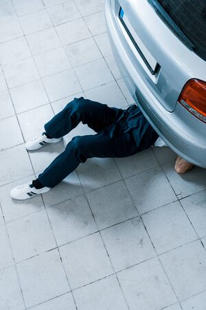 Cropped view of auto mechanic repairing car in car serviceの写真素材