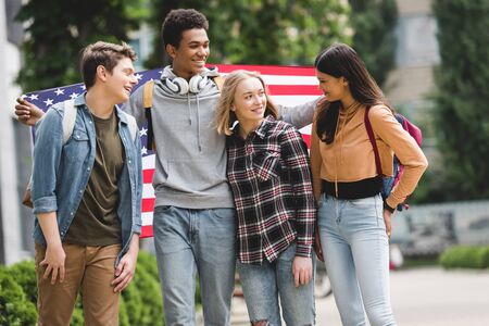 Happy and smiling teenagers holding american flag and talkingの写真素材
