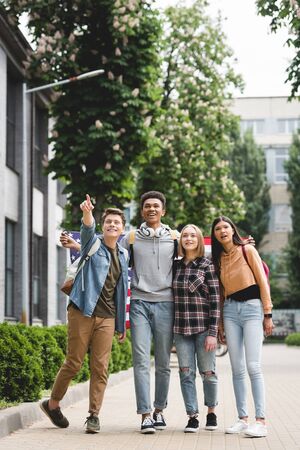 Smiling and happy teenagers holding american flag and pointing with fingerの写真素材
