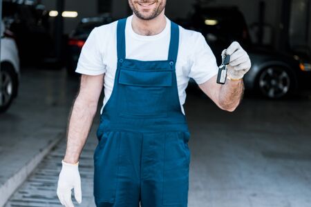 Cropped view of happy bearded car mechanic holding keysの写真素材